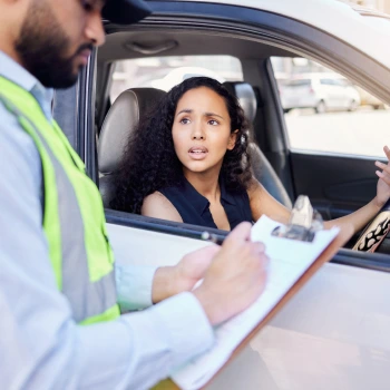 a woman sitting in a car with a police officer