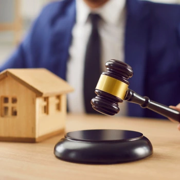 a person holding a gavel over a wooden block