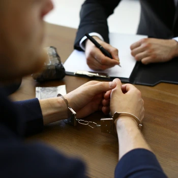 a close-up of a man's hands in handcuffs
