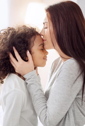 a woman kissing a child's face