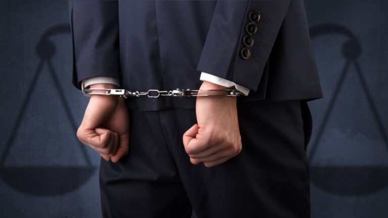 man in handcuffs with hands behind back and justice symbol wallpaper