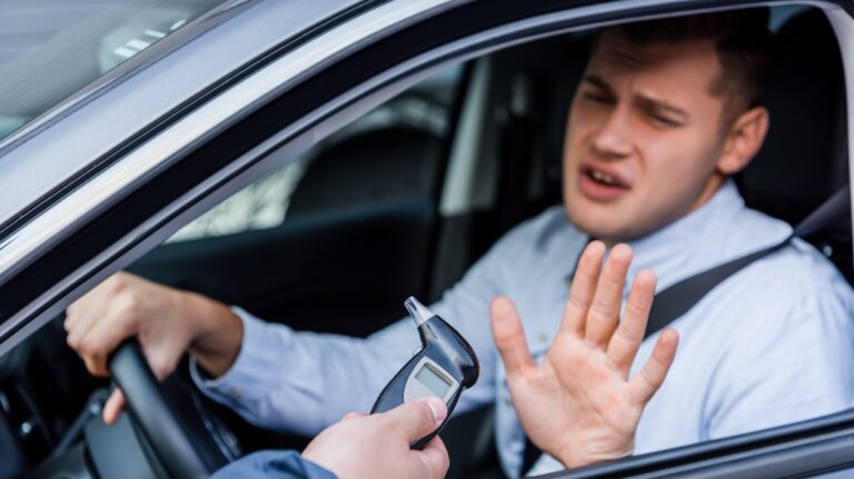 policeman giving breathalyzer to the driver