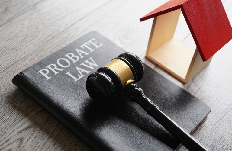 Toy house, gavel and book the PROBATE LAW are on the desk