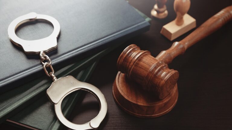 Metal handcuffs near judge gavel